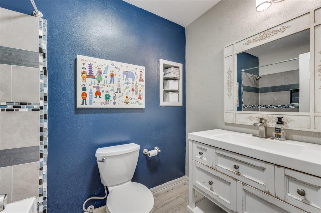 8535 Strathmore Drive Dallas, TX 75238 - Photo 11 of 23 a bathroom with a toilet a sink and mirror