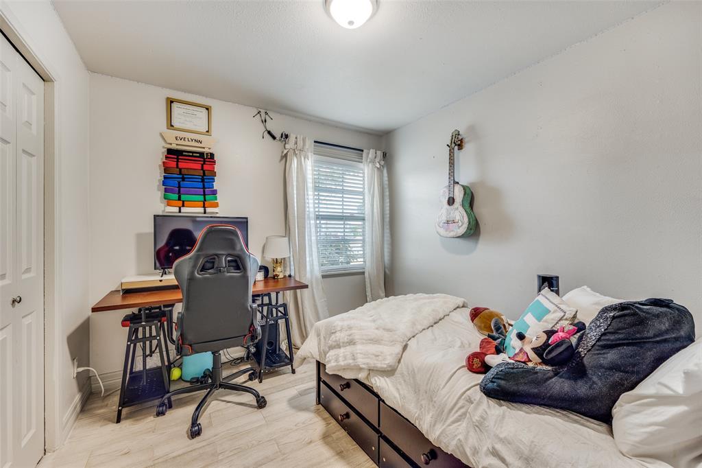 8535 Strathmore Drive Dallas, TX 75238 - Photo 12 of 23 a bedroom with a bed and a bookshelf in it
