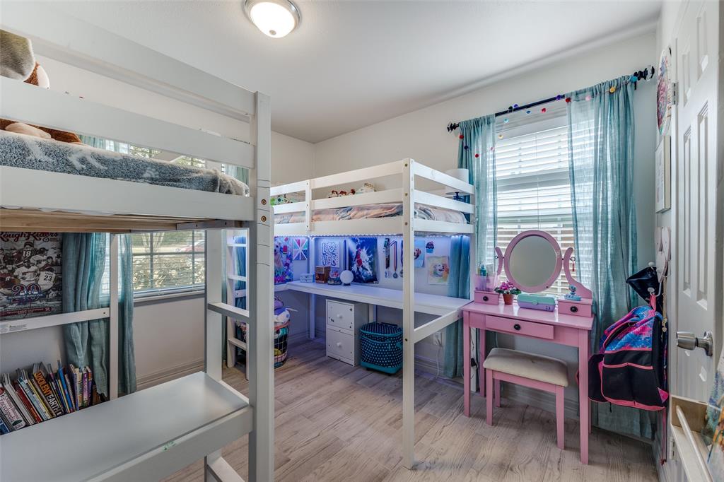 8535 Strathmore Drive Dallas, TX 75238 - Photo 13 of 23 a bedroom with a bed and a book shelf