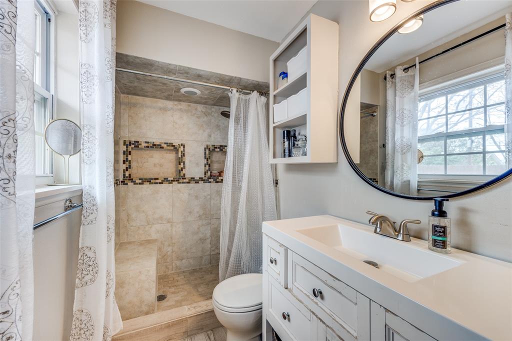8535 Strathmore Drive Dallas, TX 75238 - Photo 15 of 23 a bathroom with a sink vanity granite toilet and shower