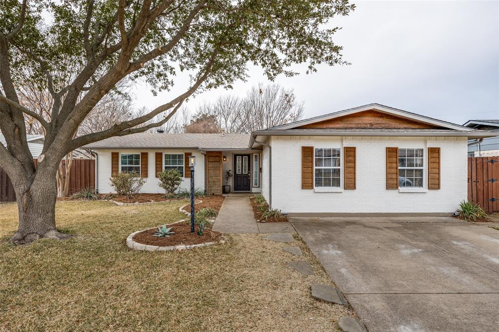 8535 Strathmore Drive Dallas, TX 75238 - Photo 22 of 23 a front view of a house with a garden and tree