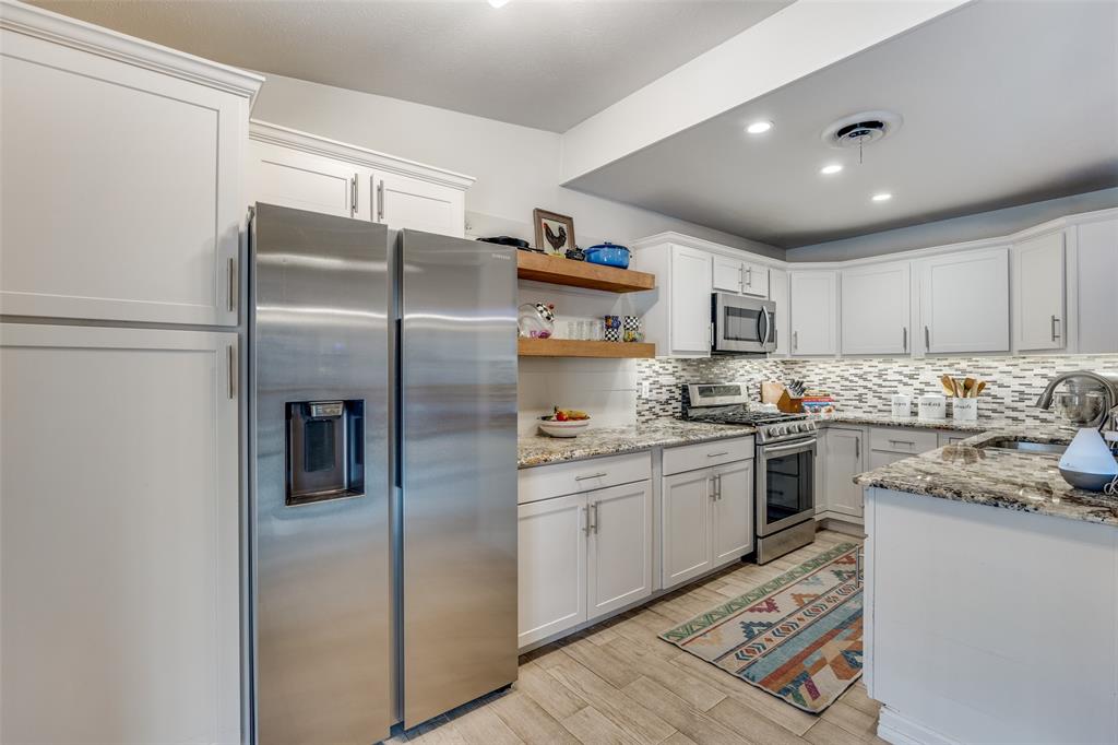 8535 Strathmore Drive Dallas, TX 75238 - Photo 7 of 23 a kitchen with stainless steel appliances granite countertop a refrigerator sink and stove