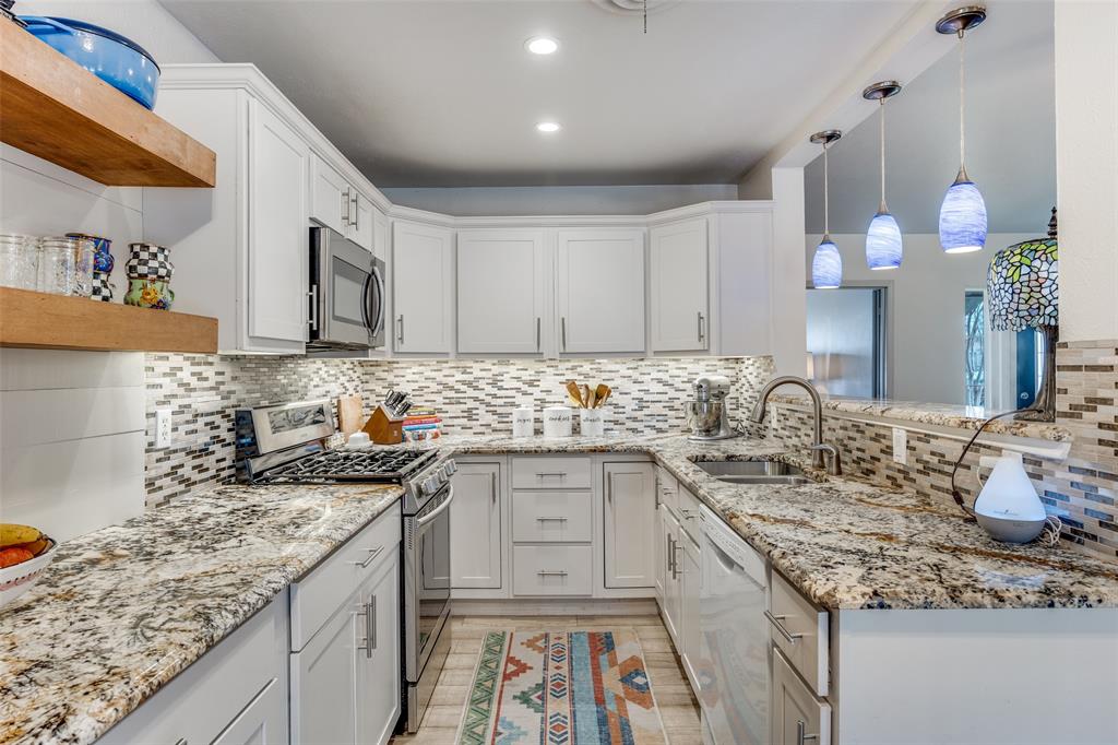 8535 Strathmore Drive Dallas, TX 75238 - Photo 8 of 23 a kitchen with granite countertop a sink stove and cabinets