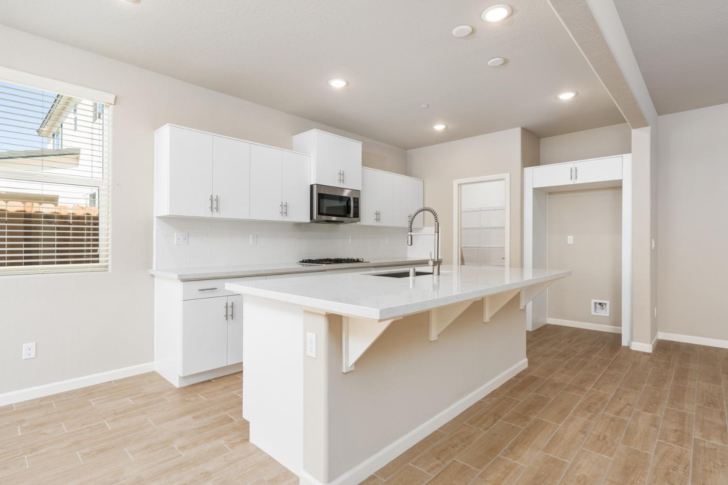 952 Pinnacle Drive Madera, CA 93636 - Photo 15 of 32 a kitchen with kitchen island a sink stainless steel appliances and cabinets
