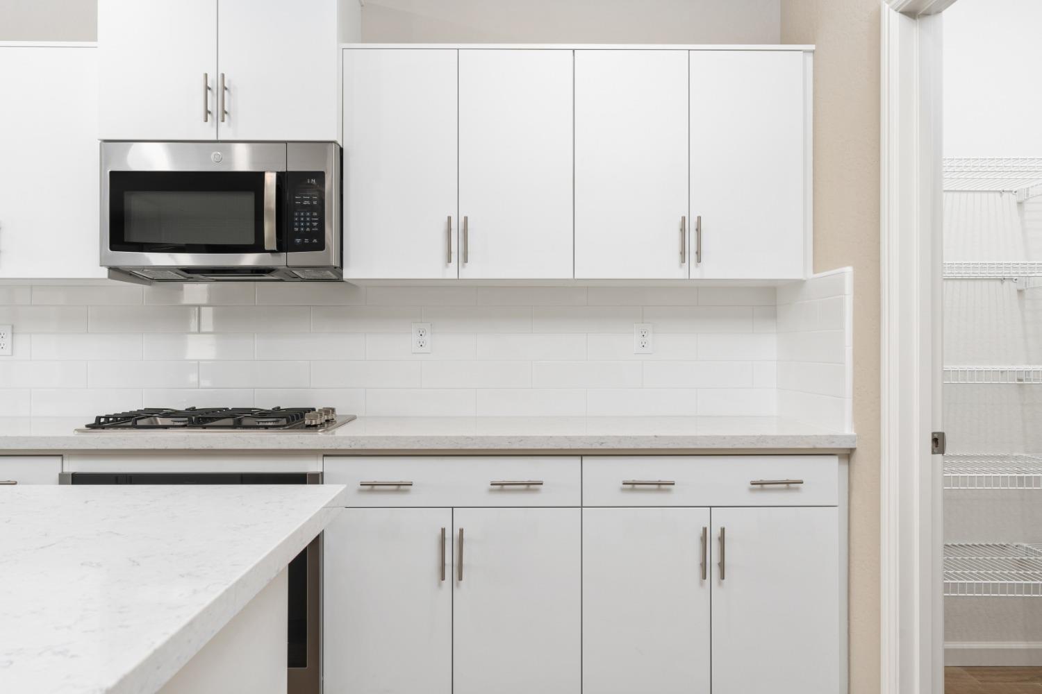 952 Pinnacle Drive Madera, CA 93636 - Photo 16 of 32 a kitchen with white cabinets and stainless steel appliances