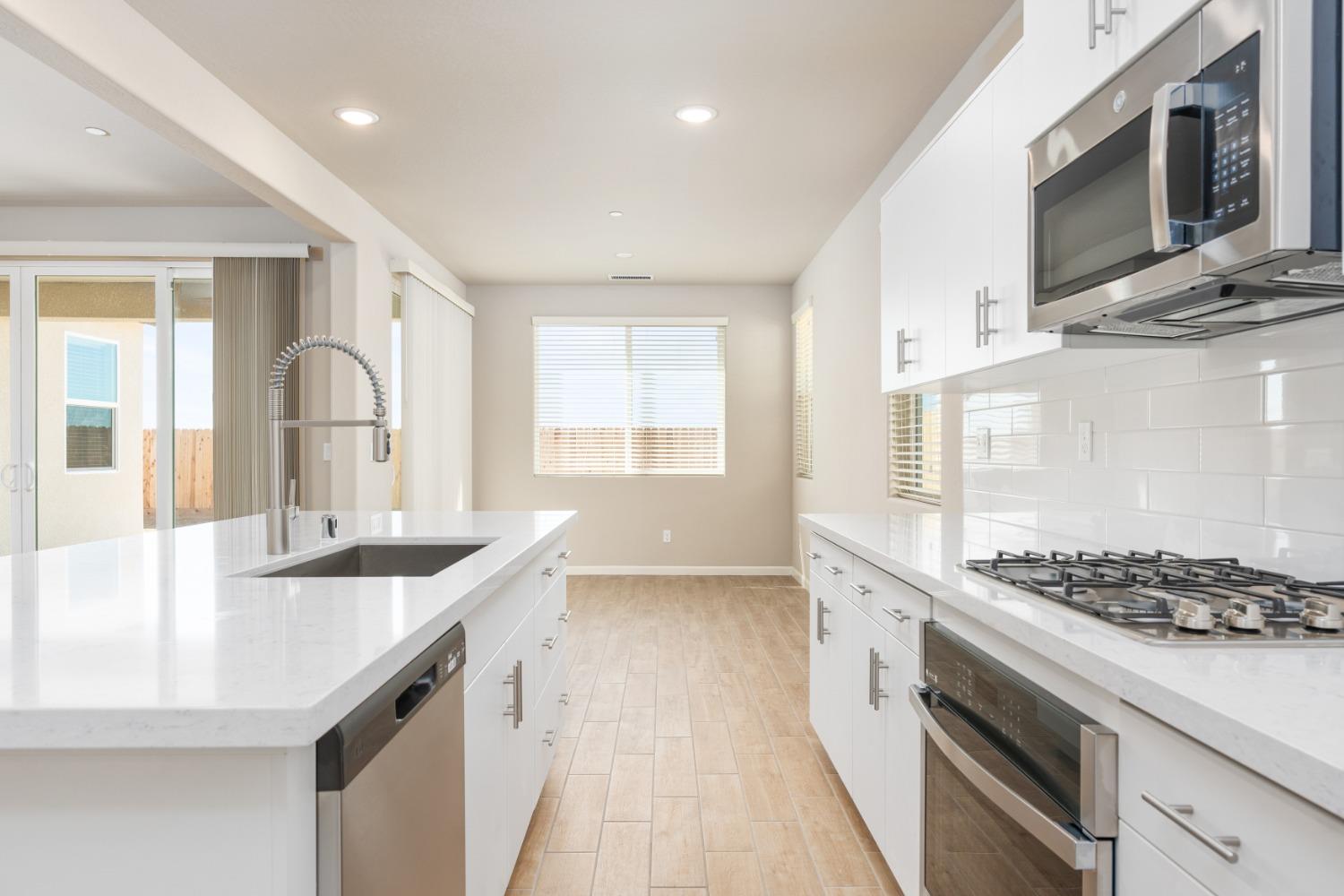 952 Pinnacle Drive Madera, CA 93636 - Photo 17 of 32 a kitchen with stainless steel appliances granite countertop a sink stove and cabinets