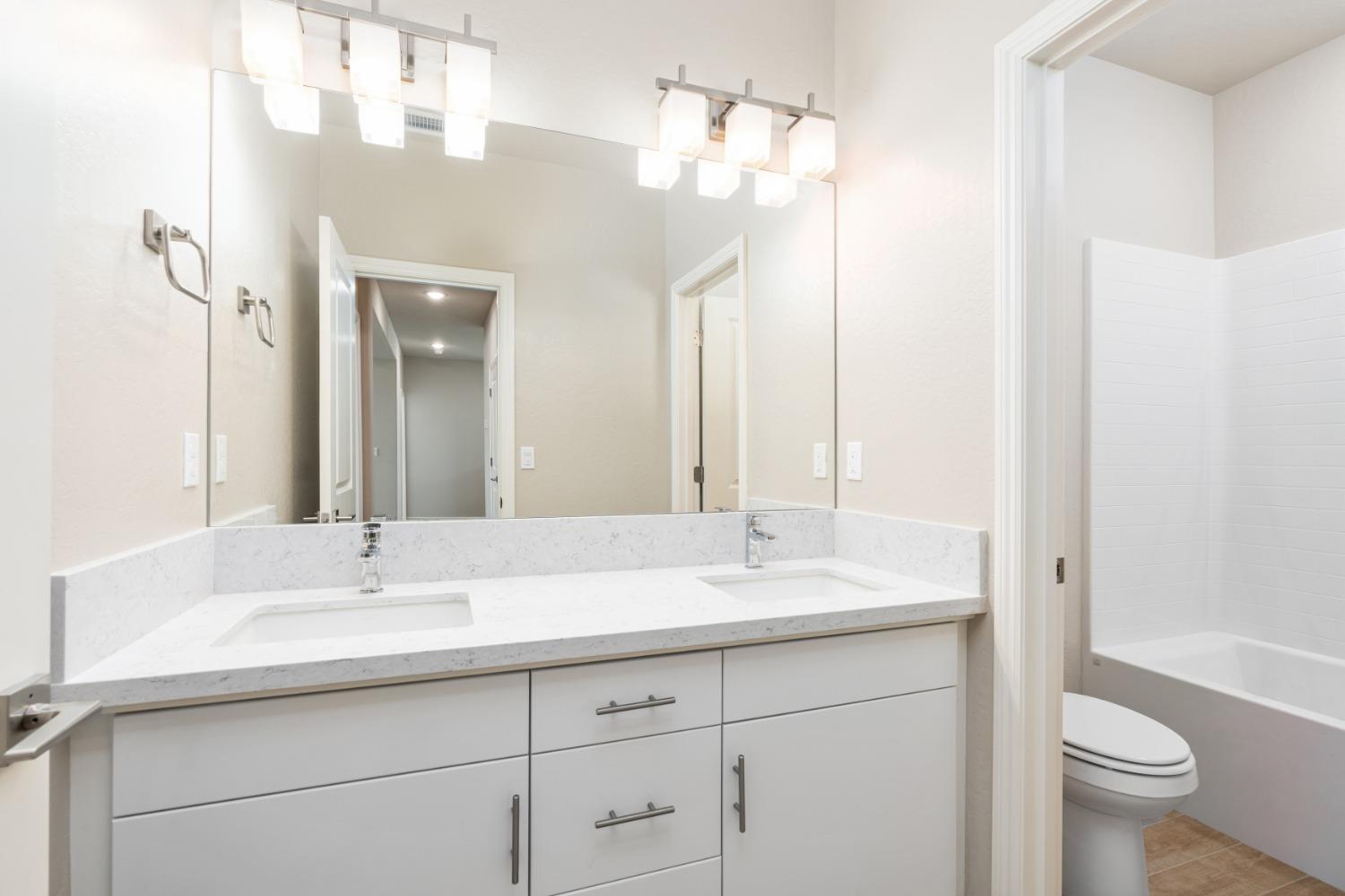952 Pinnacle Drive Madera, CA 93636 - Photo 28 of 32 a bathroom with a sink double vanity and a mirror