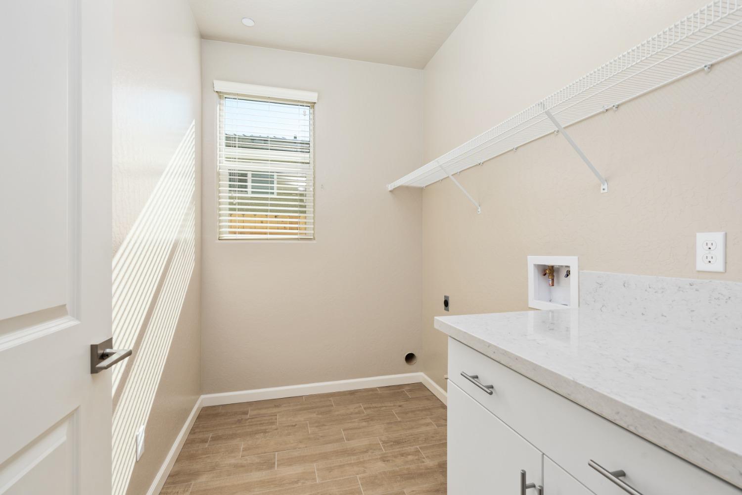 952 Pinnacle Drive Madera, CA 93636 - Photo 9 of 32 a view of a kitchen with white cabinets and wooden floor