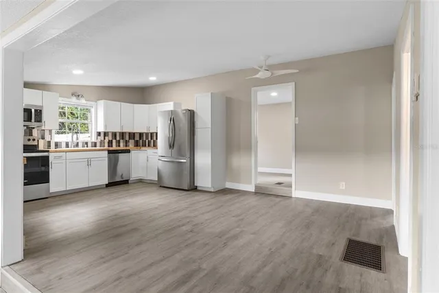 a view of kitchen with wooden floor and electronic appliances