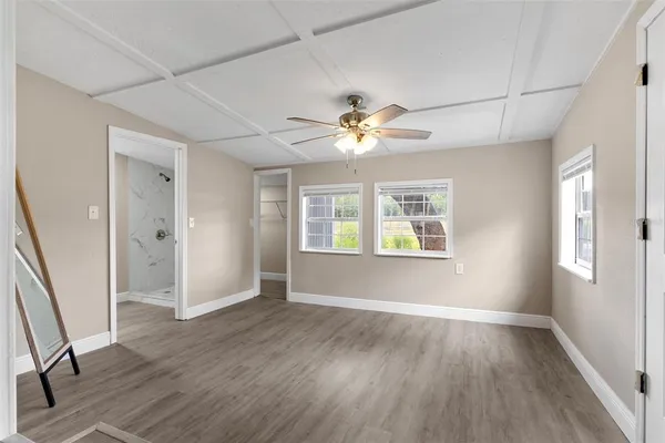an empty room with wooden floor and windows