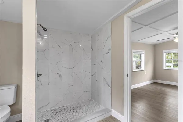 a bathroom with a granite countertop shower and a toilet