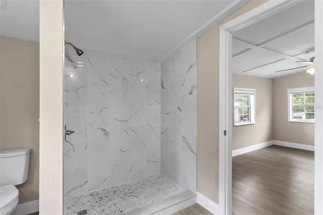 a bathroom with a granite countertop shower and a toilet