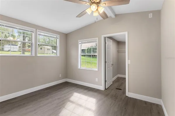an empty room with a ceiling fan and a window