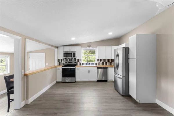 a kitchen with a refrigerator and white cabinets