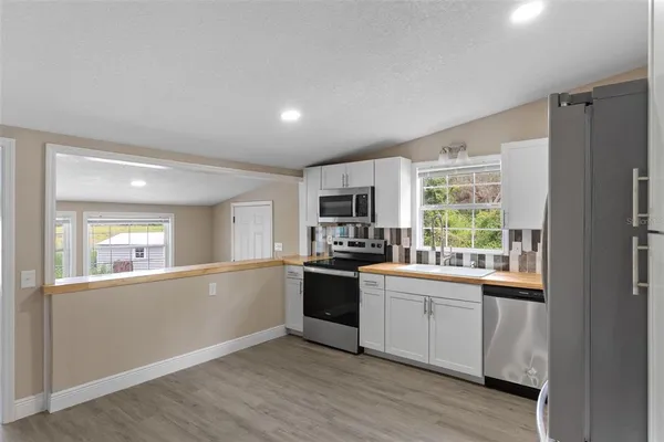 a kitchen with a sink and wooden floor