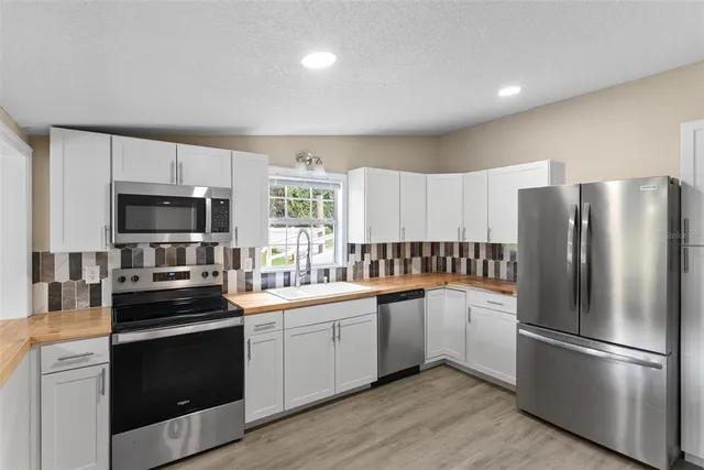 a kitchen with a sink stainless steel appliances and cabinets