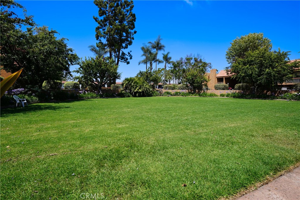 6600 Warner Avenue, Unit 88 Huntington Beach, CA 92647 - Photo 18 of 25 a view of a garden with a building in the background