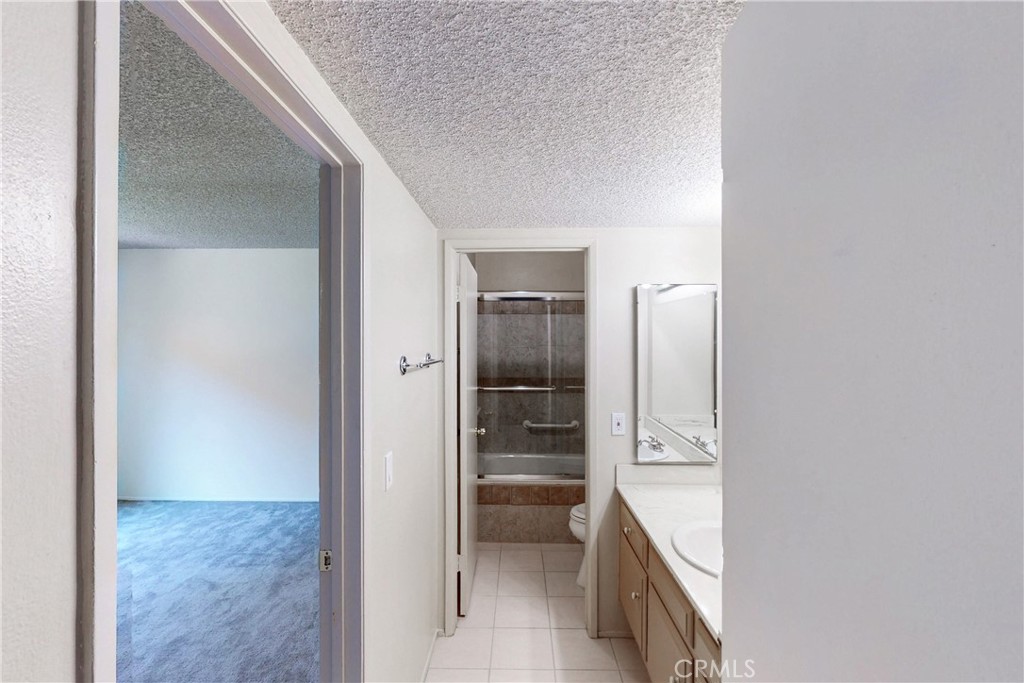 6600 Warner Avenue, Unit 88 Huntington Beach, CA 92647 - Photo 4 of 25 a bathroom with a granite countertop sink and washing machine