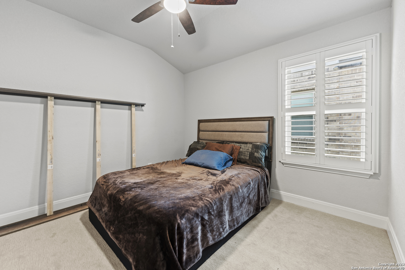 12136 Icon Ridge San Antonio, TX 78253 - Photo 24 of 26 a bedroom with a bed window and a chandelier