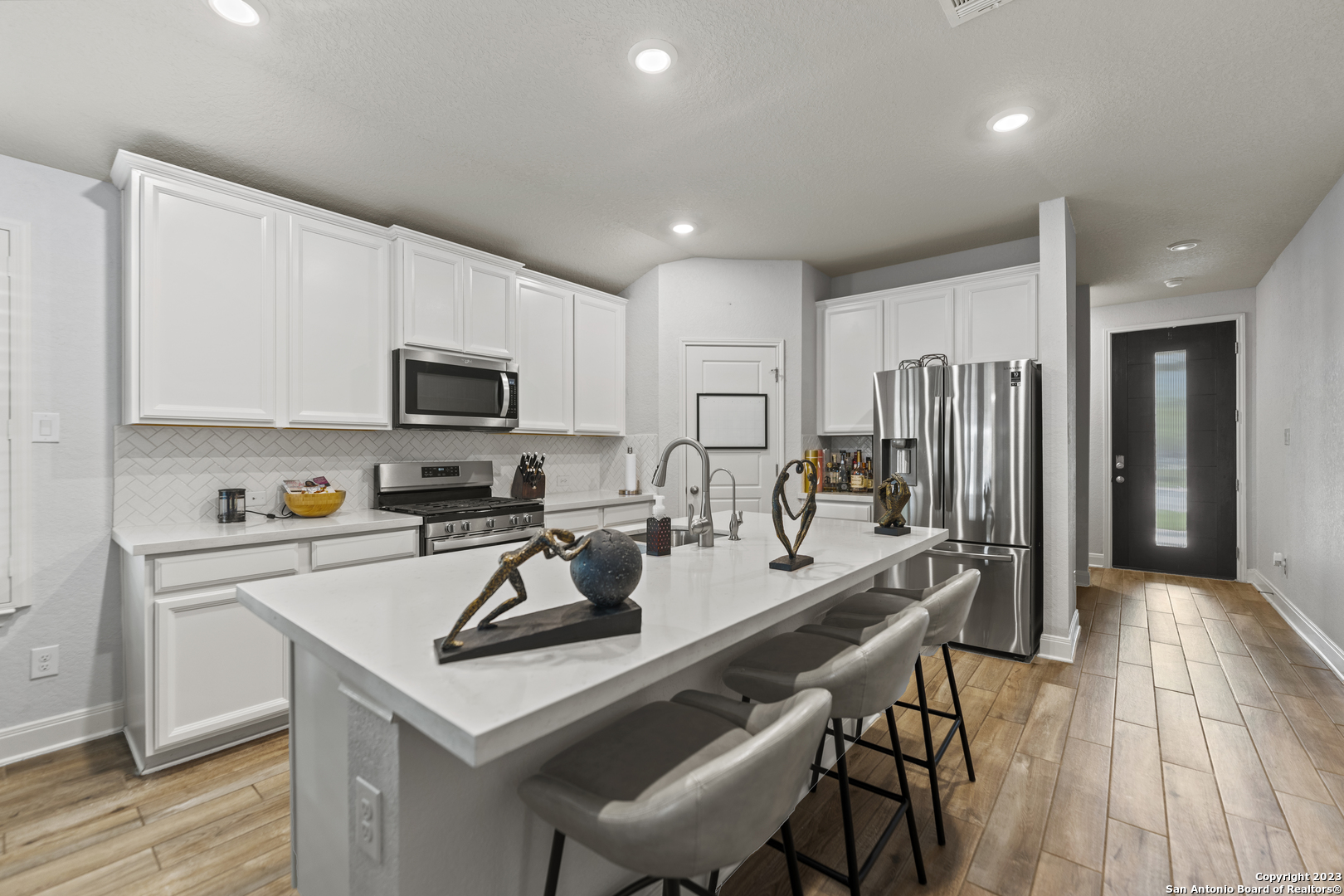 12136 Icon Ridge San Antonio, TX 78253 - Photo 3 of 26 a kitchen with a table chairs microwave and refrigerator