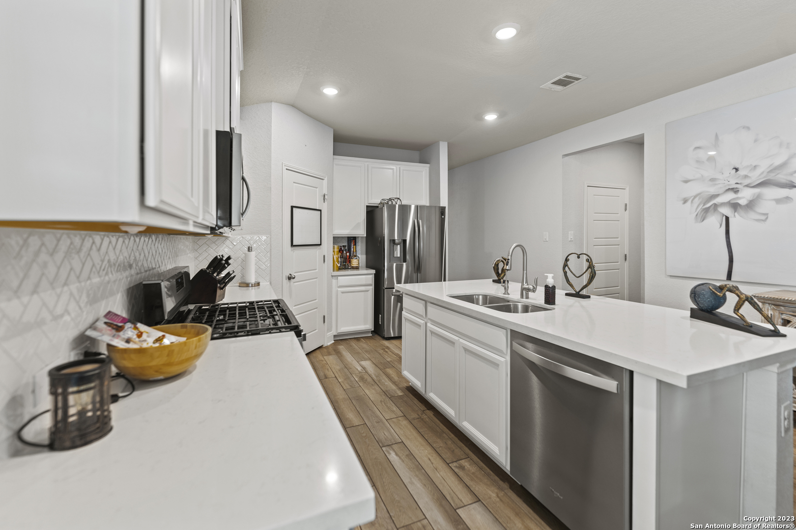 12136 Icon Ridge San Antonio, TX 78253 - Photo 4 of 26 a large white kitchen with a sink a stove and a refrigerator