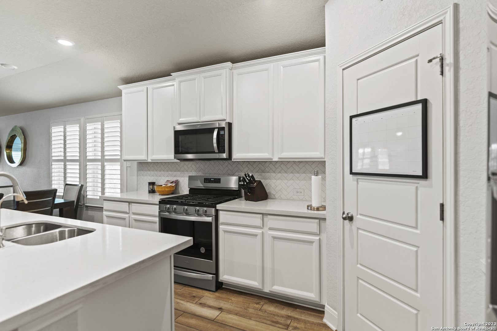 12136 Icon Ridge San Antonio, TX 78253 - Photo 6 of 26 a kitchen with white cabinets and black appliances