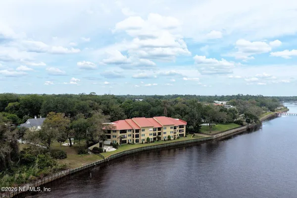 an aerial view of a house with a garden and lake view
