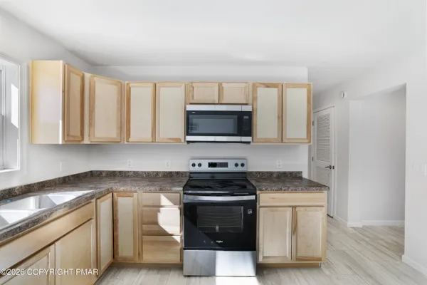 a kitchen with granite countertop a stove and a sink