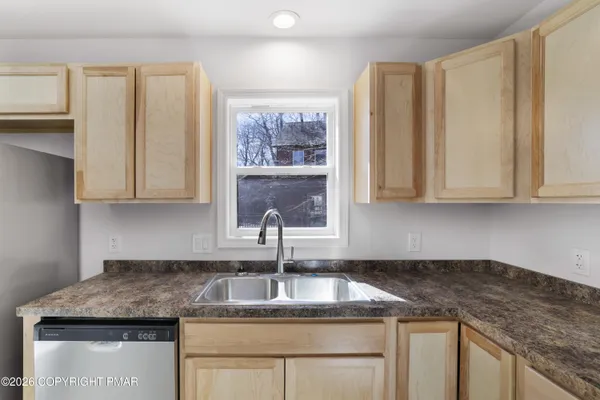 a kitchen with granite countertop white cabinets and sink
