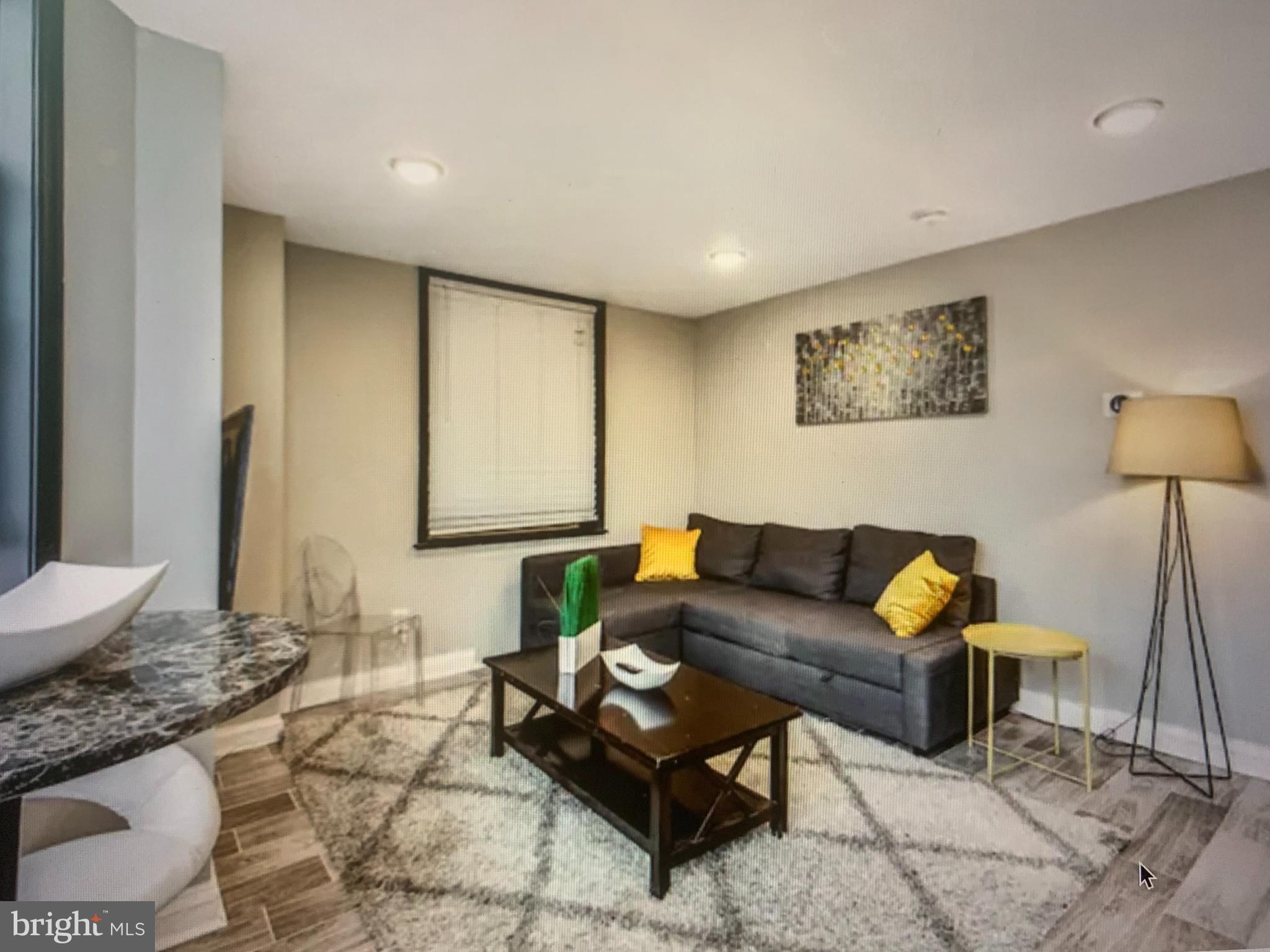 2135 Walnut Street, Unit 901 Philadelphia, PA 19103 - Photo 2 of 8 a living room with furniture and a lamp
