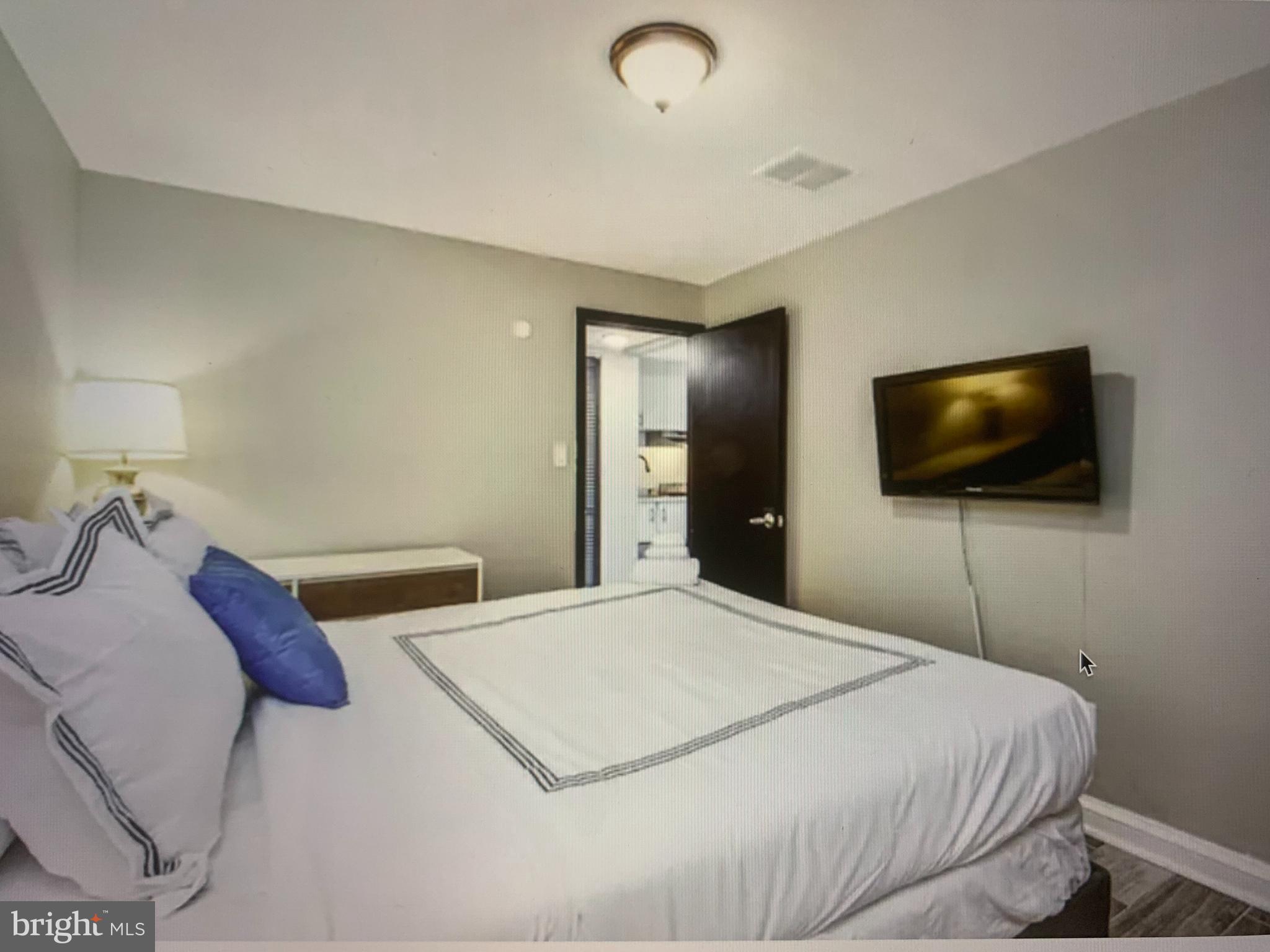 2135 Walnut Street, Unit 901 Philadelphia, PA 19103 - Photo 3 of 8 a bedroom with a bed and a flat screen tv