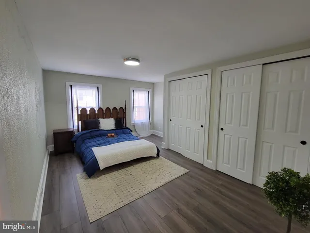 a bedroom with a bed window and wooden floor