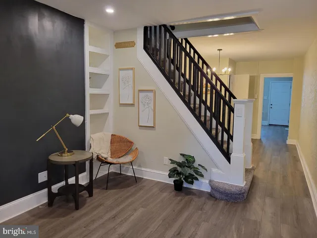 a view of a hallway with wooden floor and furniture