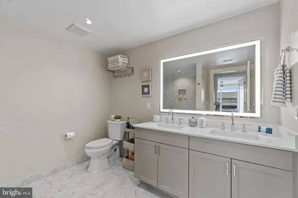 a bathroom with a toilet sink and mirror