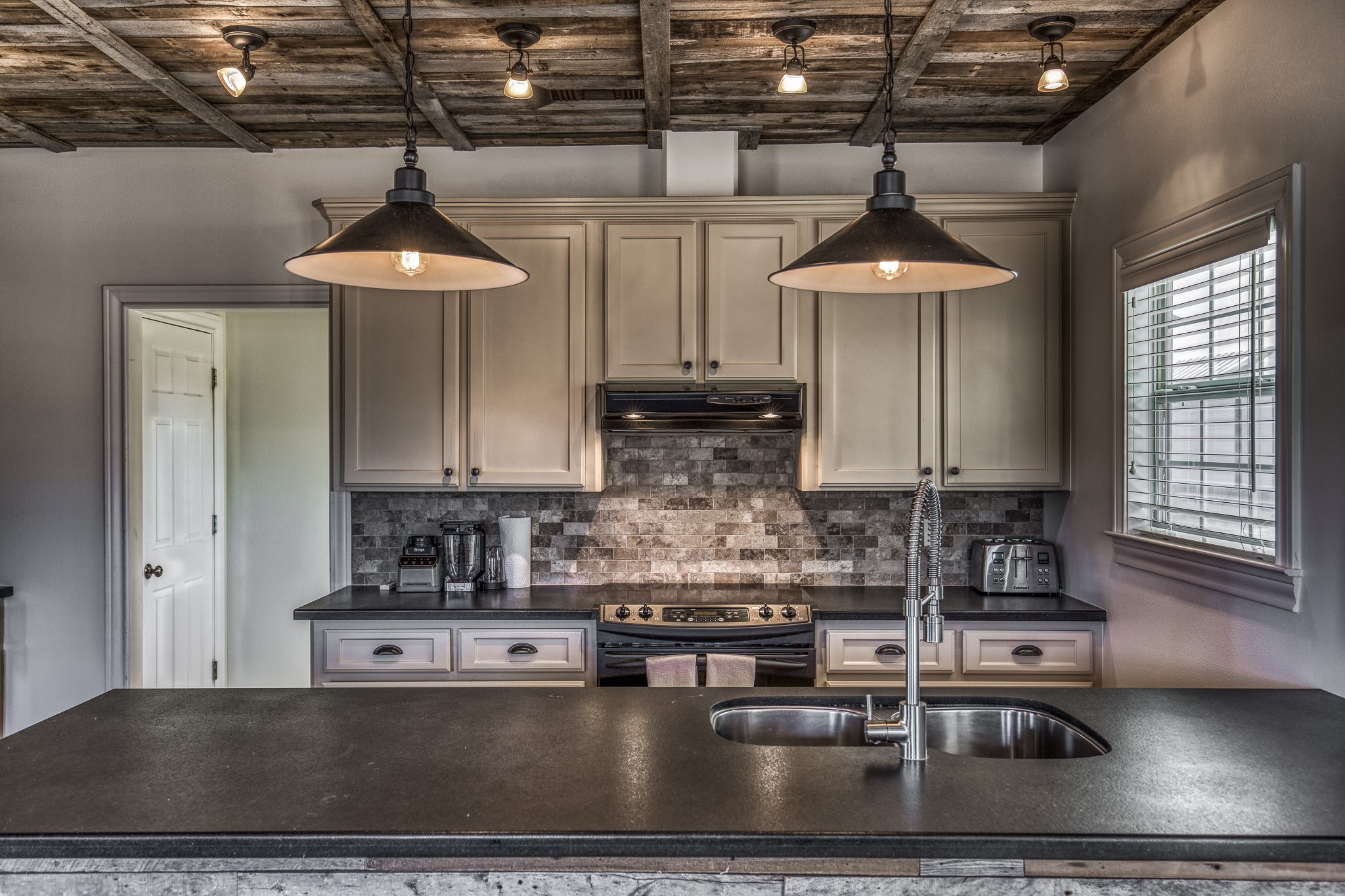 1712 Lynn Road Chappell Hill, TX 77426 - Photo 39 of 44 a kitchen with stainless steel appliances granite countertop a sink a stove and a wooden cabinets