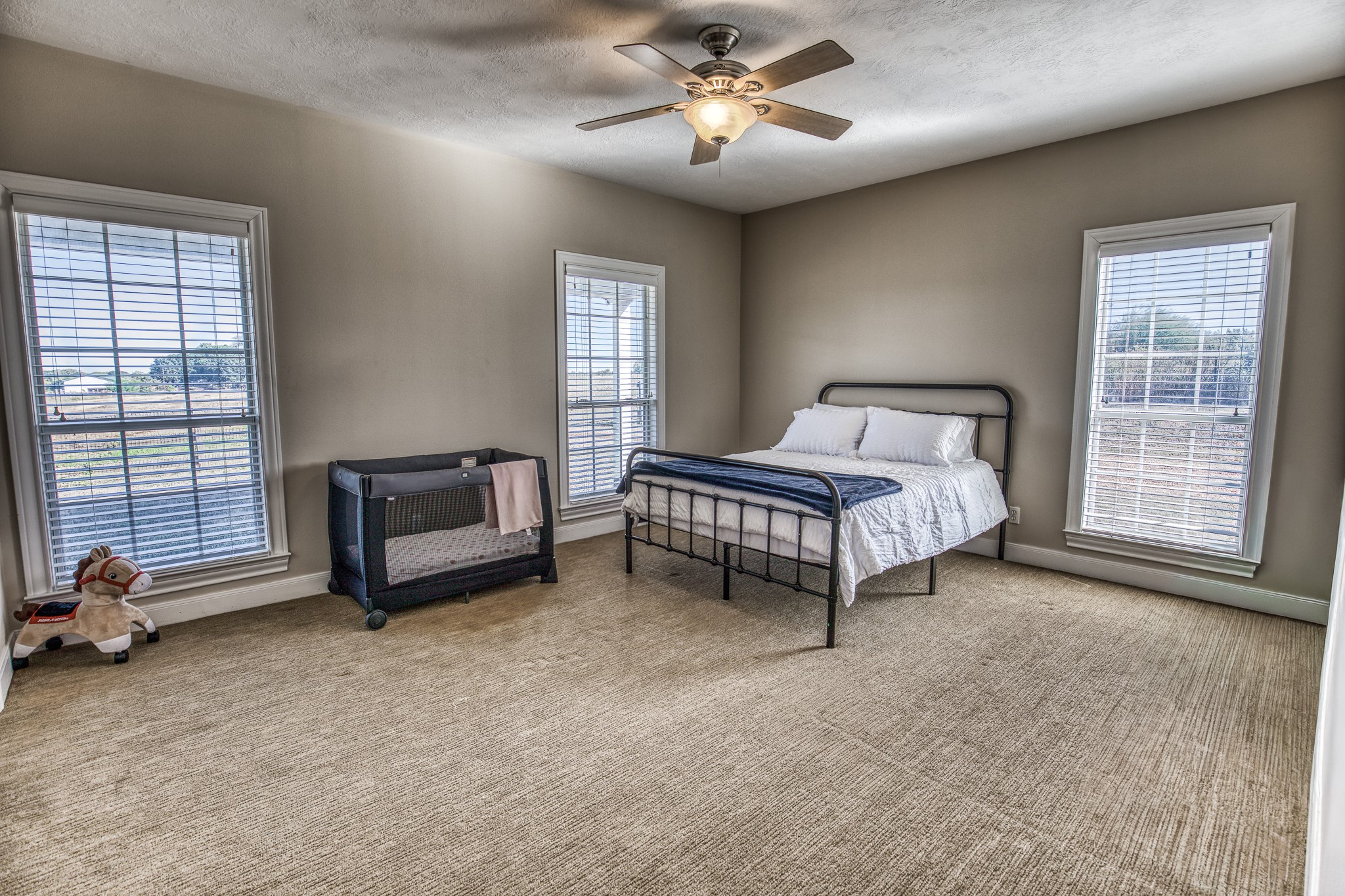 1712 Lynn Road Chappell Hill, TX 77426 - Photo 42 of 44 a spacious bedroom with a bed a chandelier and a window