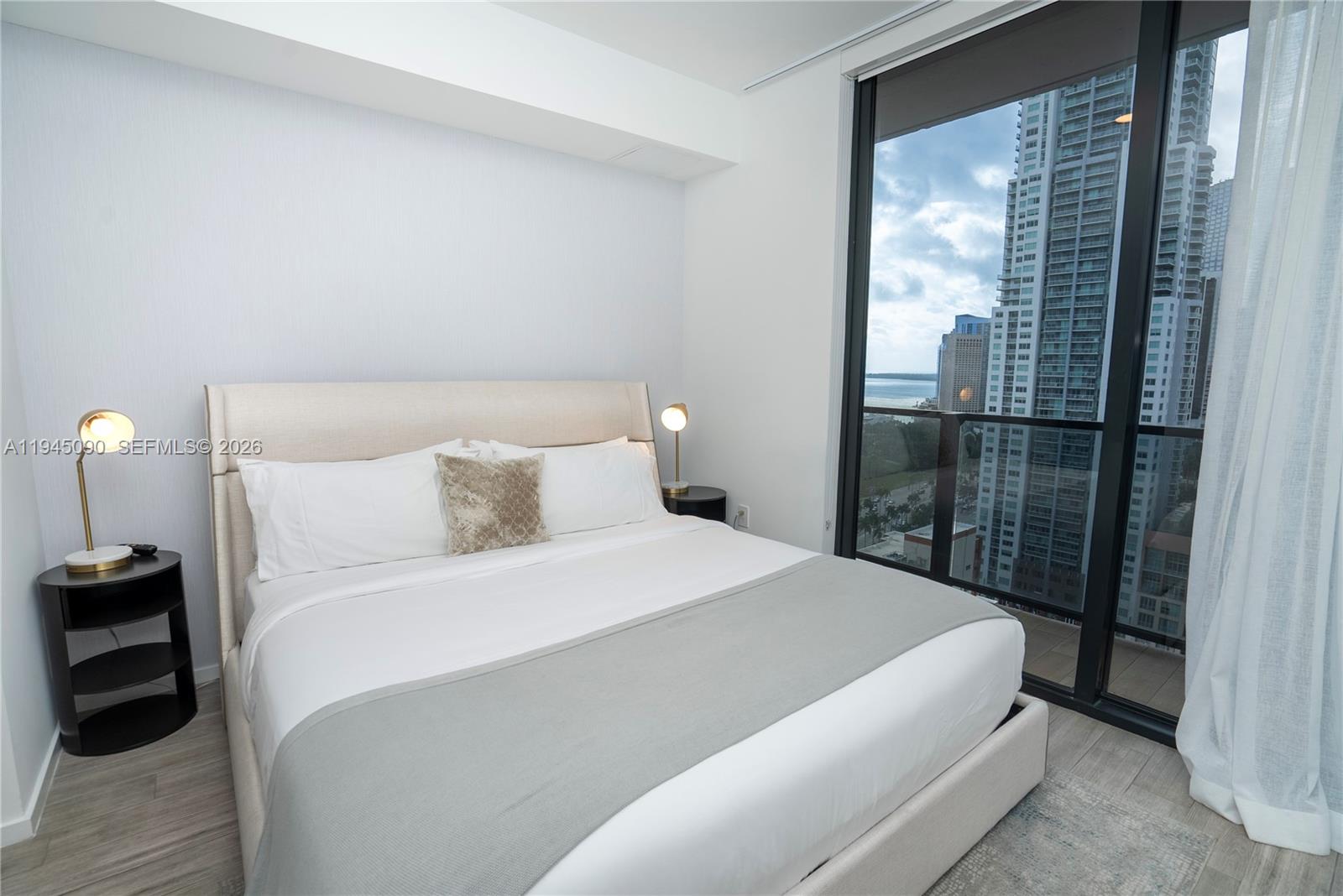 398 Northeast 5th Street, Unit 1617 Miami, FL 33132 - Photo 17 of 18 a bedroom with a bed and a mirror