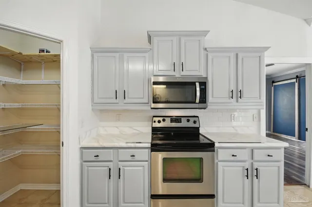 a front view of a house with a garden and trees