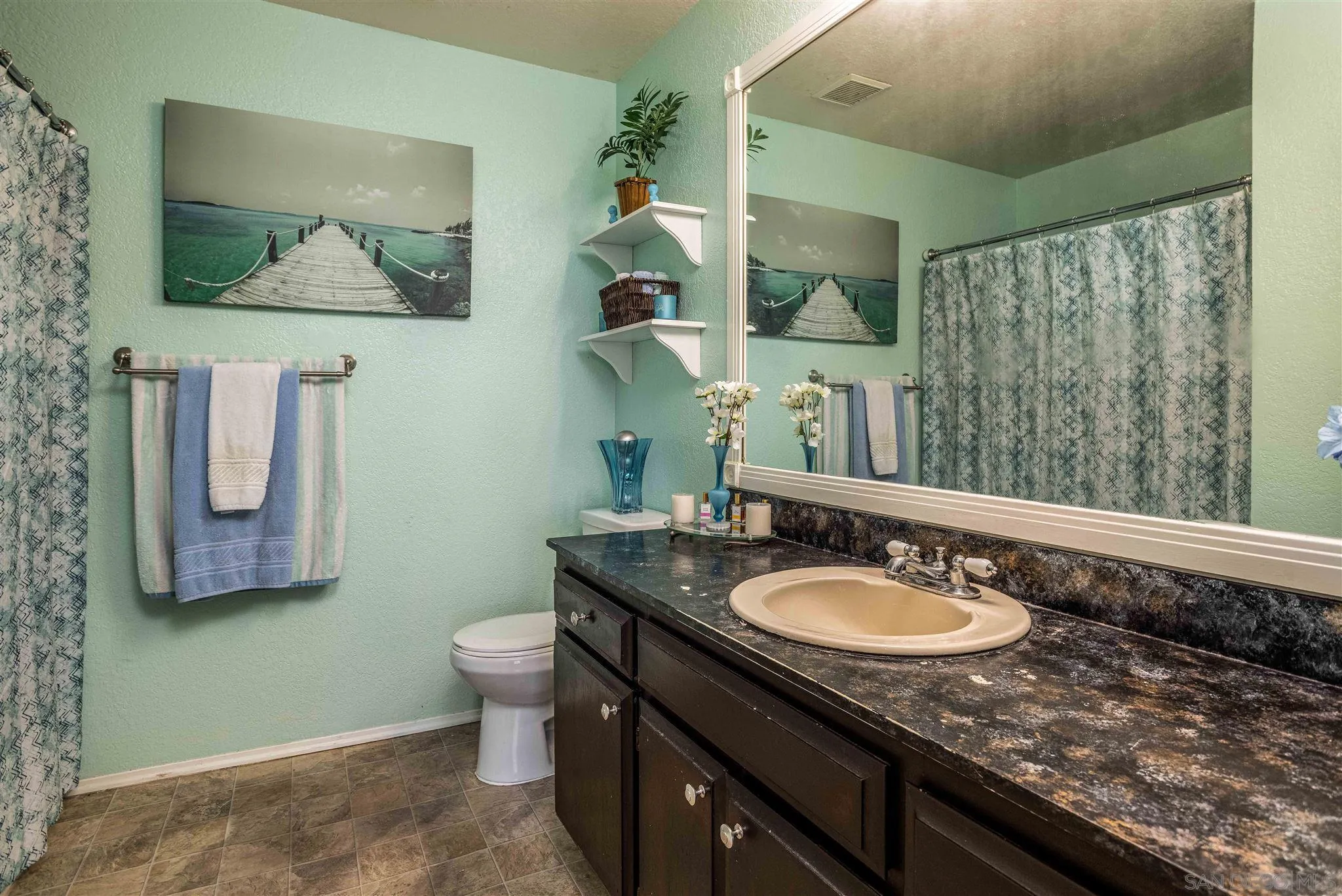24392 Rutherford Road Ramona, CA 92065 - Photo 20 of 29 a bathroom with a granite countertop sink a mirror and a toilet