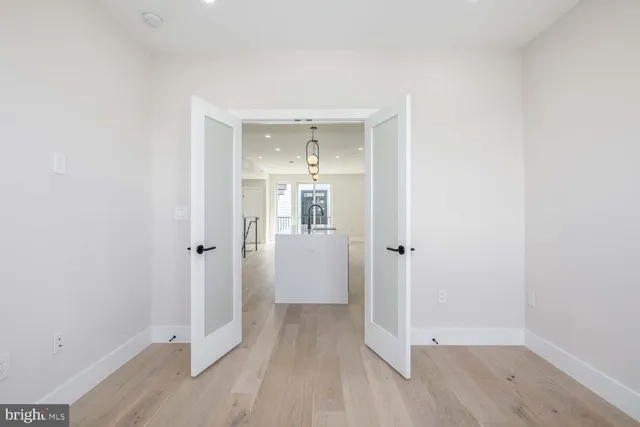 a view of a hallway with wooden floor and closet area