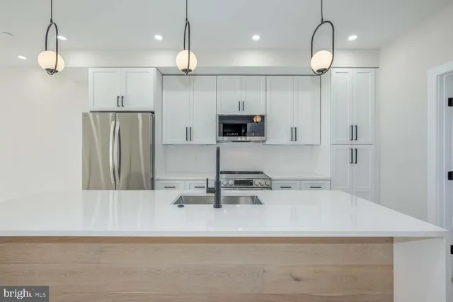 a kitchen with kitchen island a sink stainless steel appliances and refrigerator