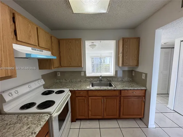 a kitchen with a sink a stove and cabinets