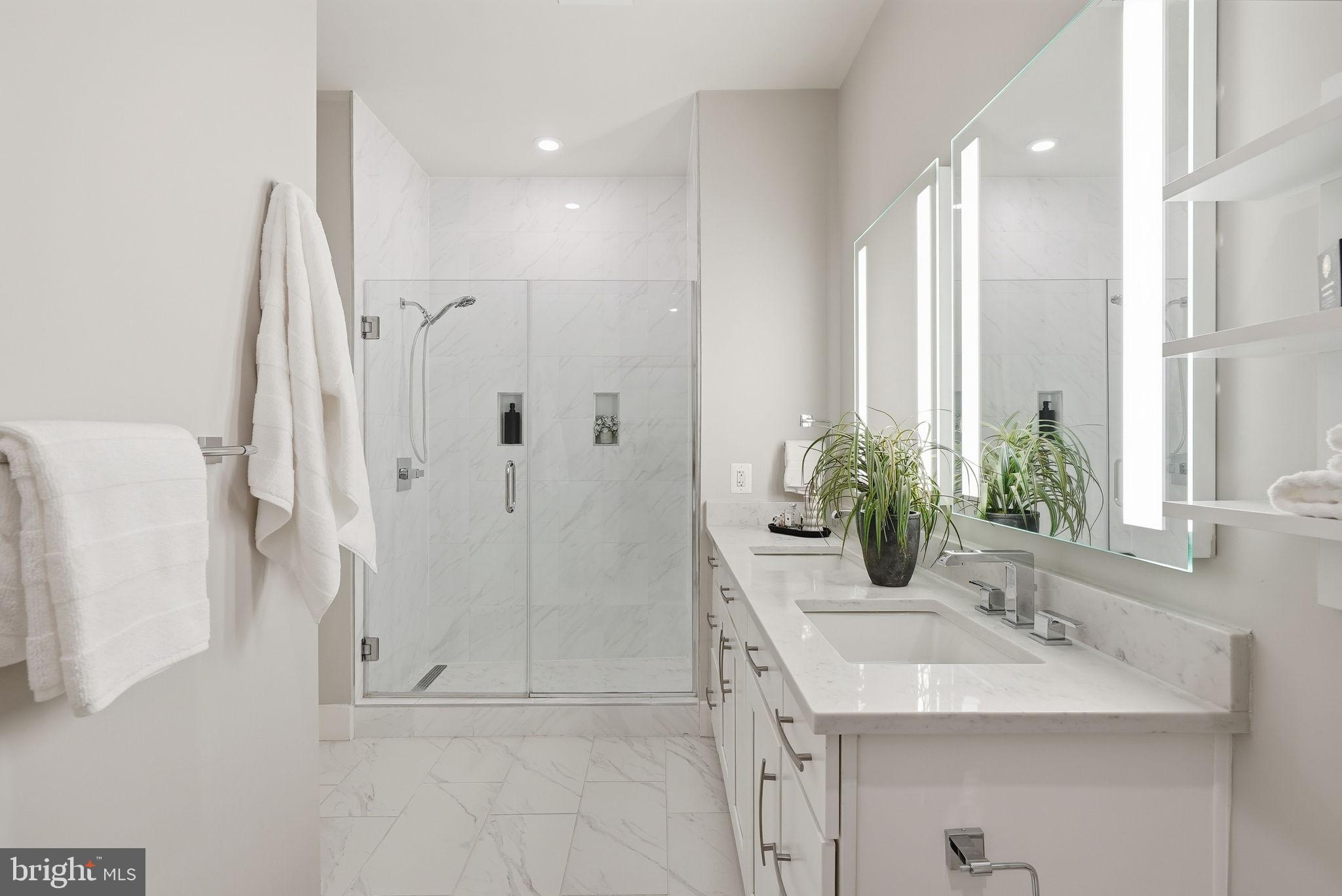 1411 Key Boulevard, Unit 505 Arlington, VA 22209 - Photo 14 of 26 a bathroom with a sink a mirror and a shower