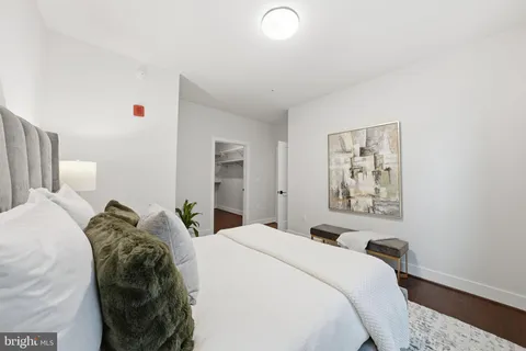 a bedroom with a bed and a painting on the wall