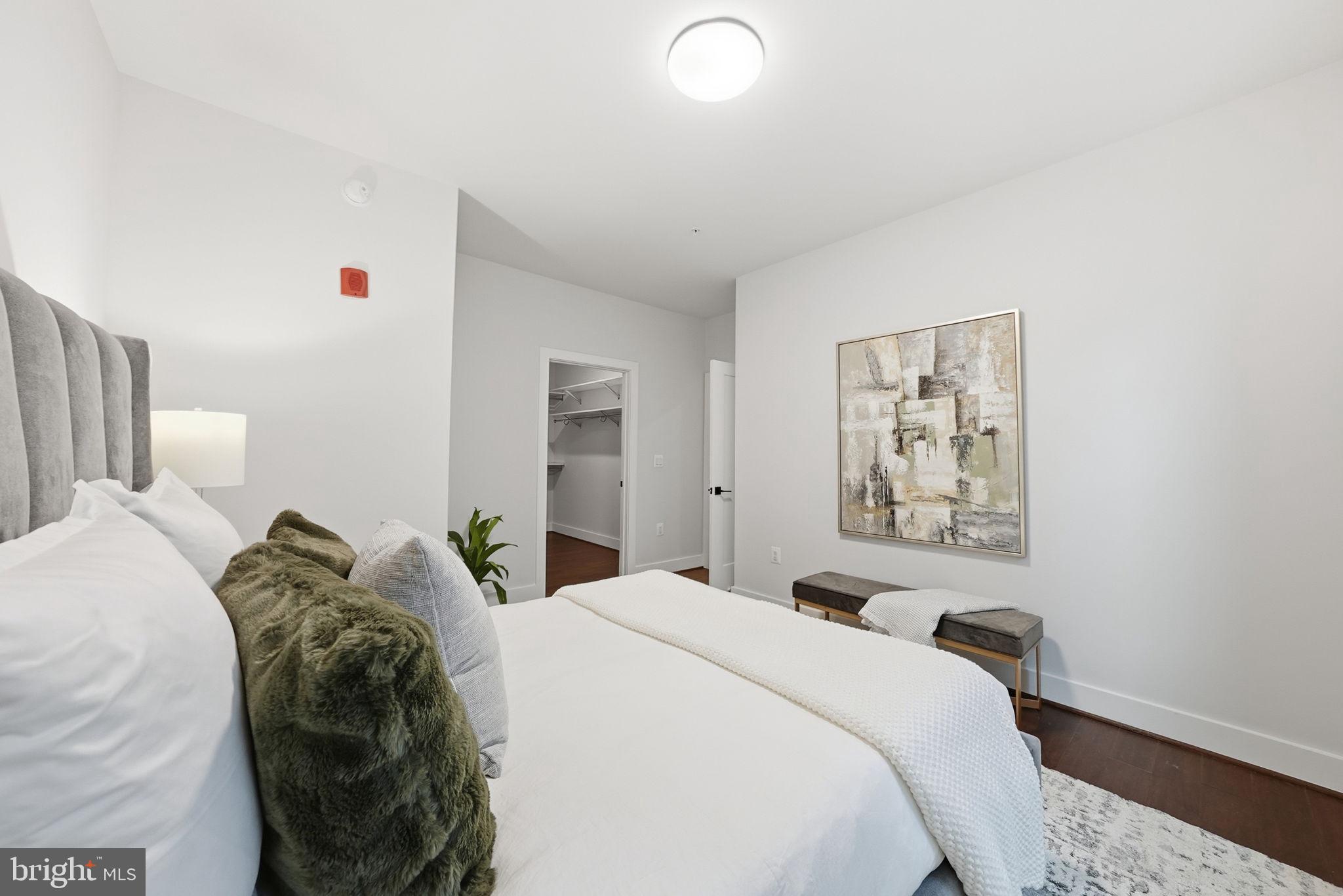 1411 Key Boulevard, Unit 505 Arlington, VA 22209 - Photo 17 of 26 a bedroom with a bed and a painting on the wall