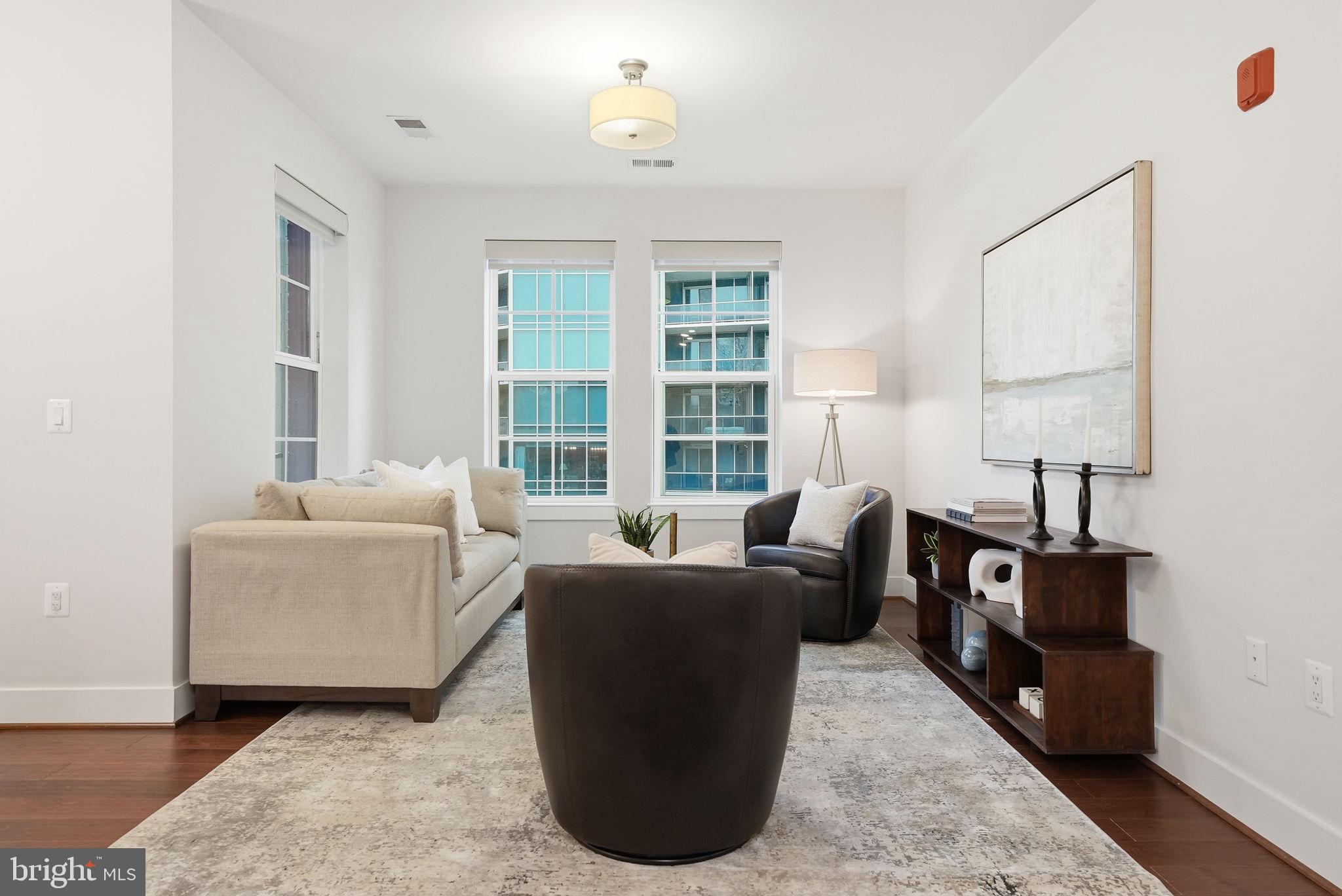 1411 Key Boulevard, Unit 505 Arlington, VA 22209 - Photo 3 of 26 a living room with furniture wooden floor and a large window