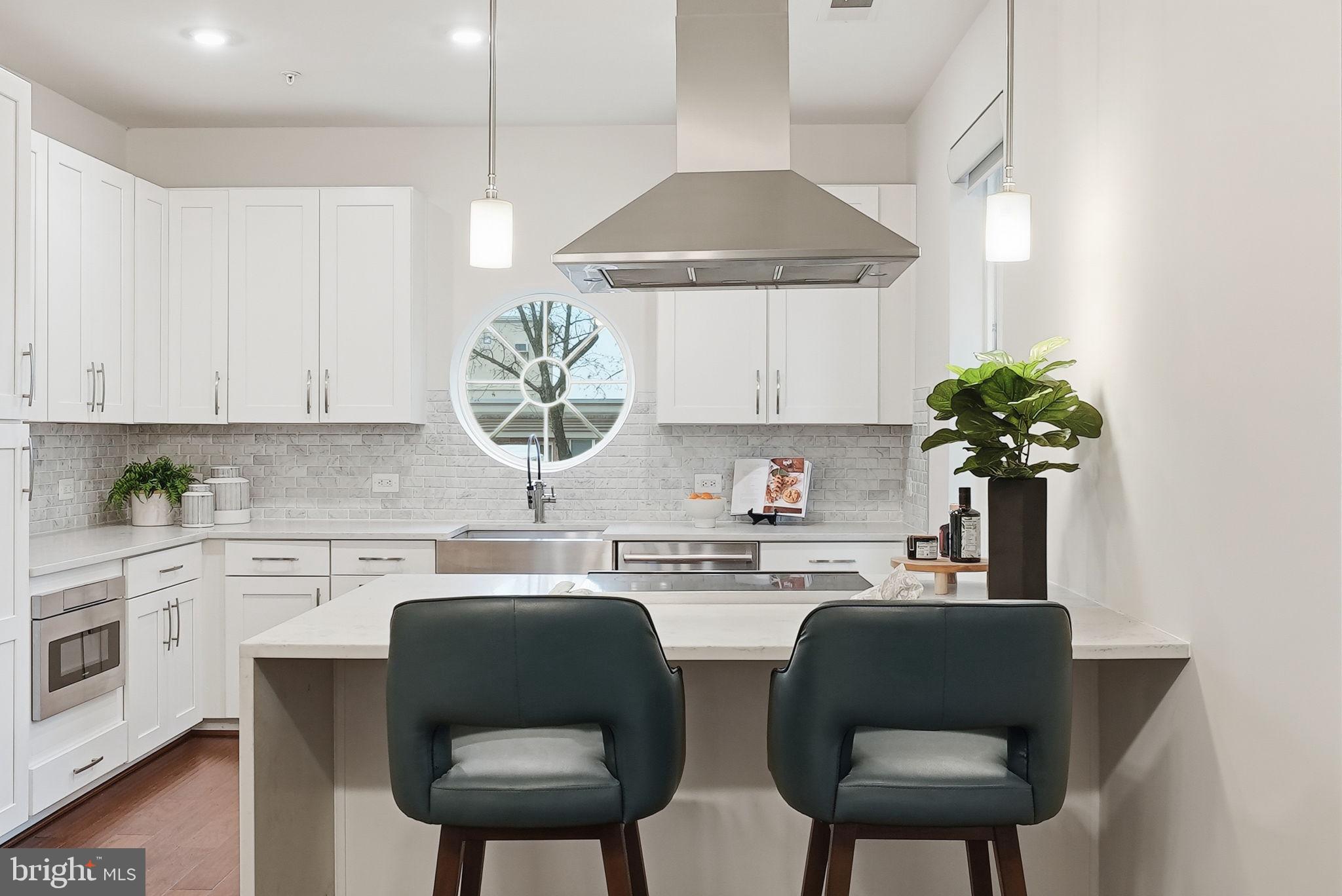 1411 Key Boulevard, Unit 505 Arlington, VA 22209 - Photo 6 of 26 a kitchen with stainless steel appliances a table and chairs in it