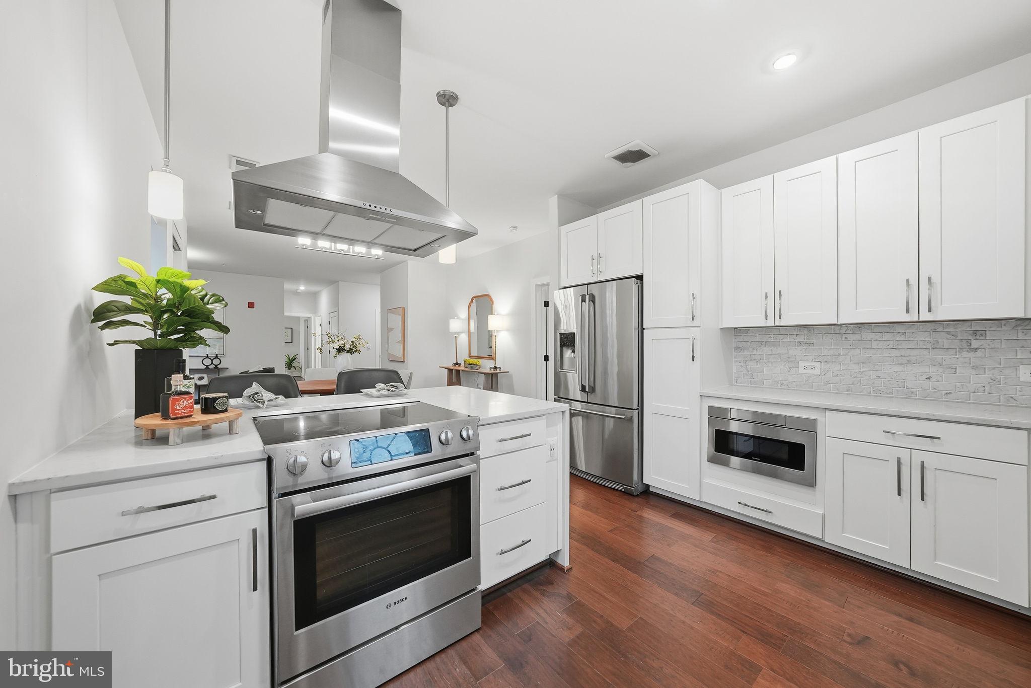 1411 Key Boulevard, Unit 505 Arlington, VA 22209 - Photo 8 of 26 a kitchen with stainless steel appliances white cabinets and a stove