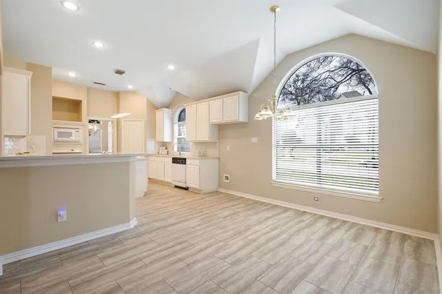 a view of a kitchen with wooden floor and a window