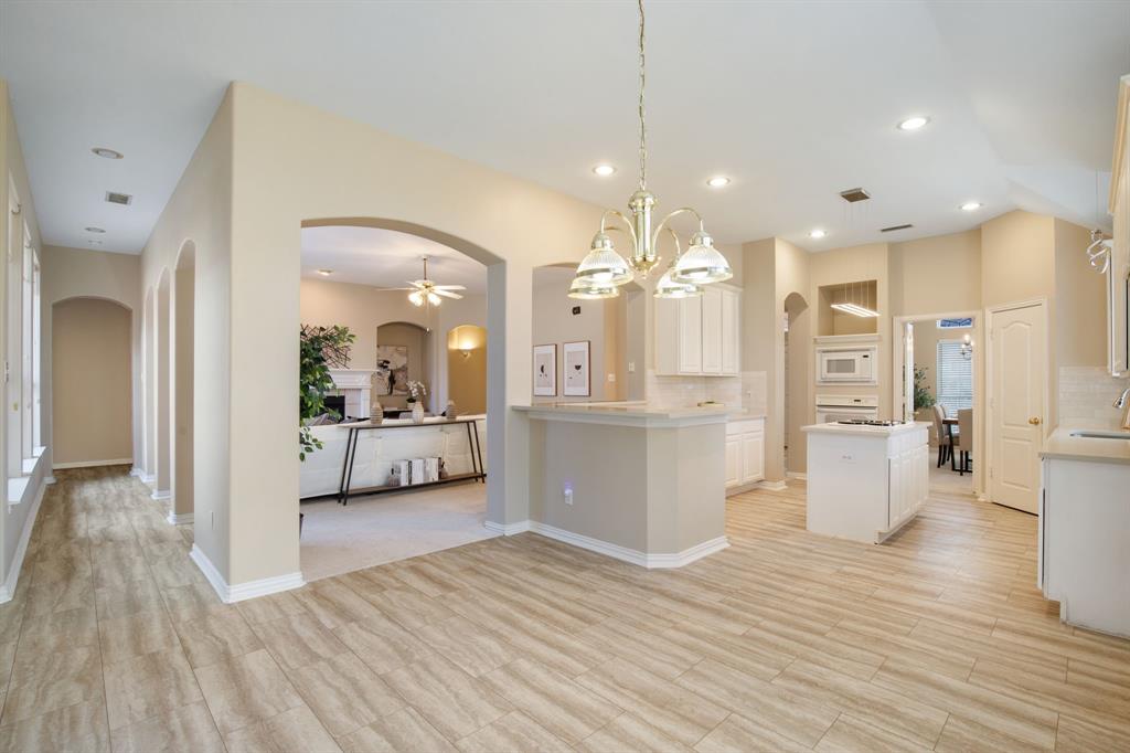 921 West Muirfield Road Garland, TX 75044 - Photo 14 of 33 a view of a kitchen with refrigerator and a wooden floor